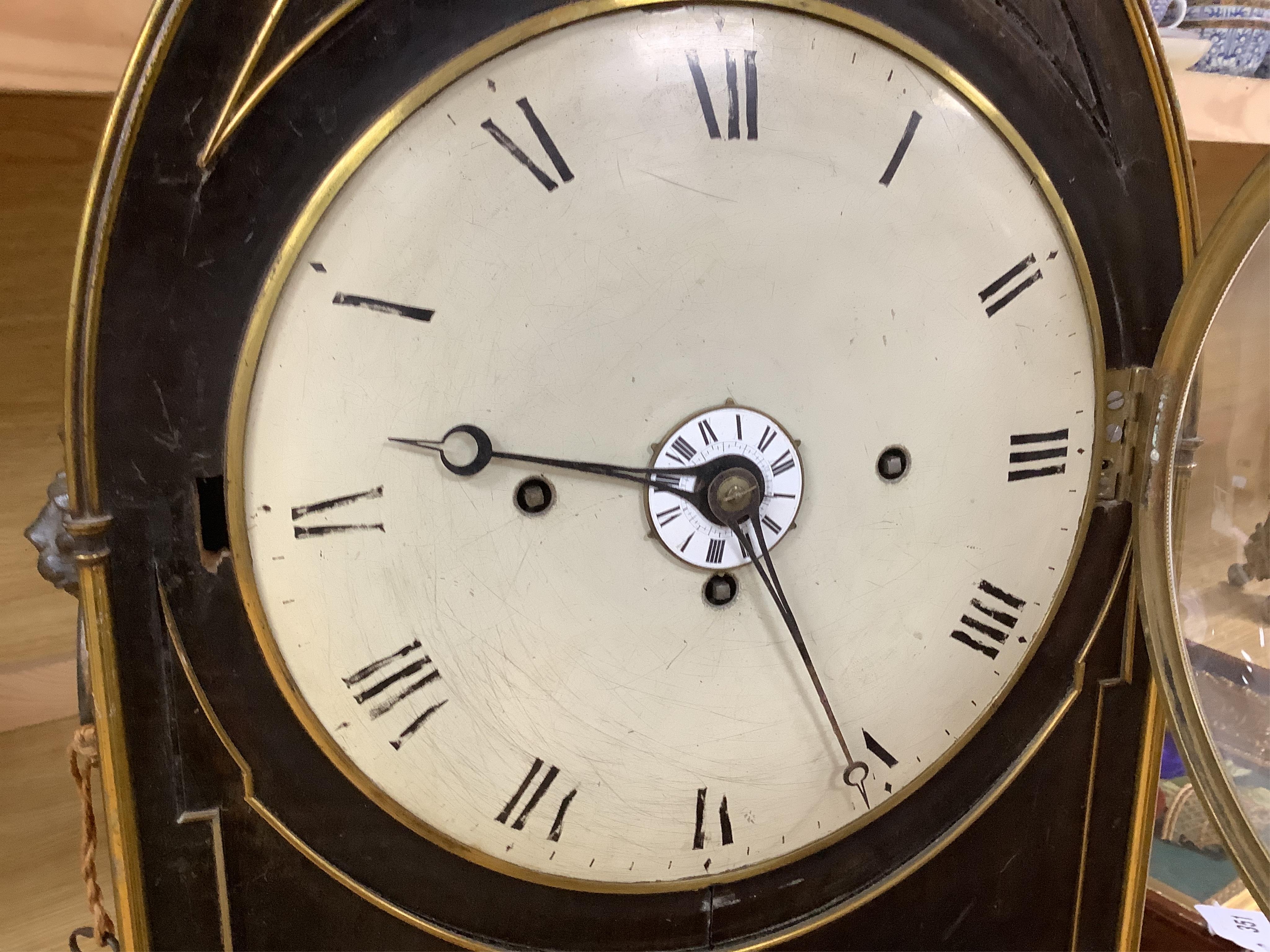 A Regency ebonised and brass inlaid lancet-shape bracket clock, with key and a painted pottery strut timepiece, largest 55cm high (2)